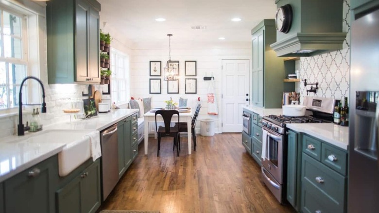 large kitchen with green cabinets 