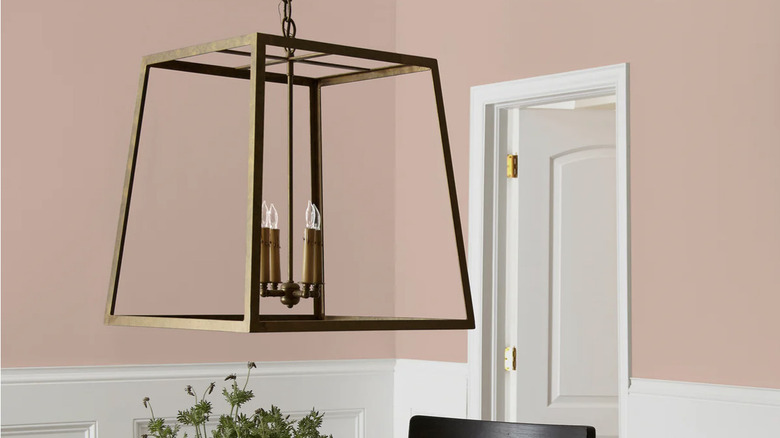 Wall painted with Rosy Pink by Magnolia with gold lamp in foreground