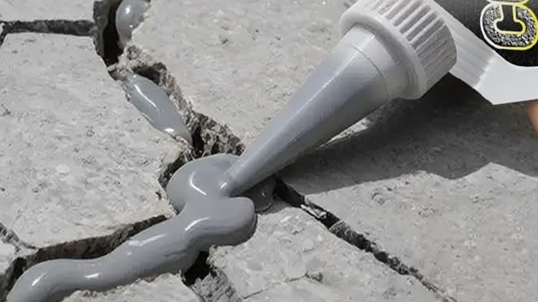 Crack filler being applied to a cracked driveway paver