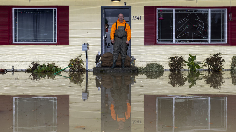Man surveys flooding in front of home.