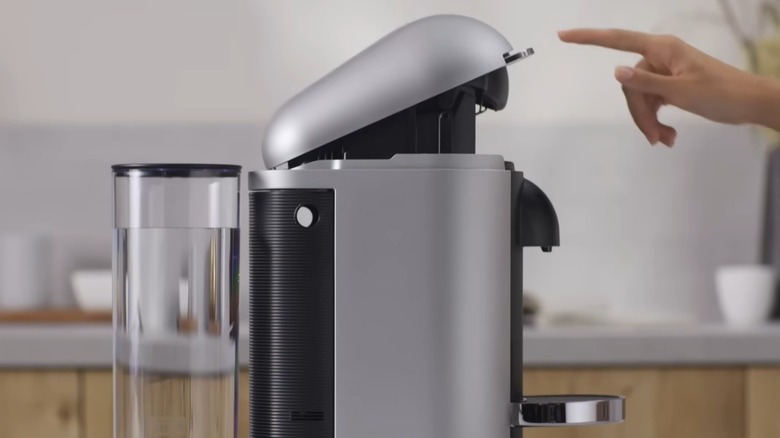 Person cleaning a Nespresso coffee maker