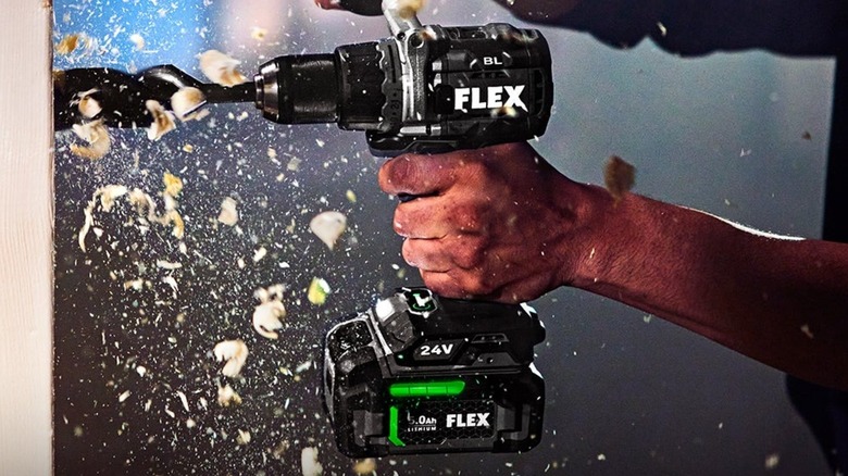 Man using Flex 24V 1/2in 2-Speed Drill Driver to drill hole in wood stud