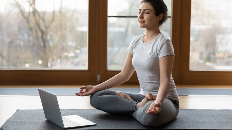 Woman meditating in meditation room 