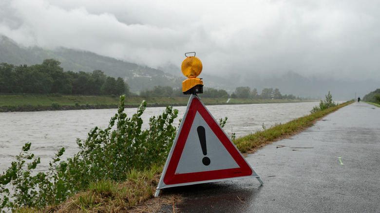 Caution sign at a river during flood