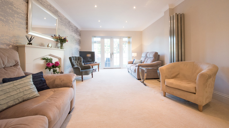 A living room with wall-to-wall beige carpet