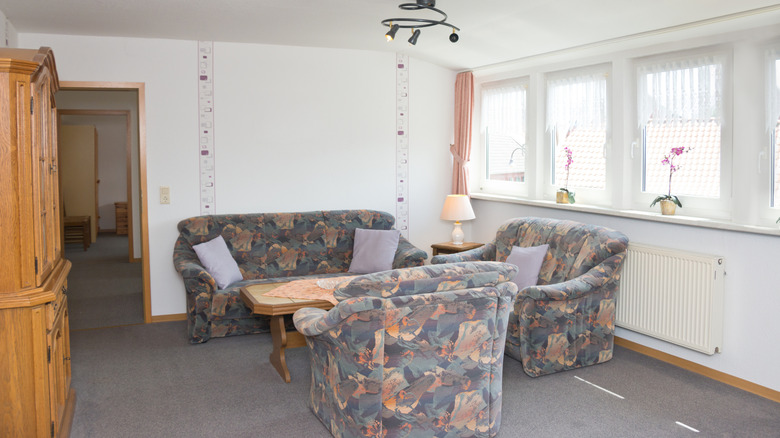 A late 20th century living room with low-pile gray carpet
