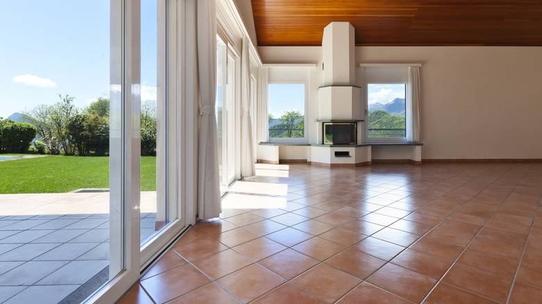 A well-lit, empty living room with wood parquet flooring