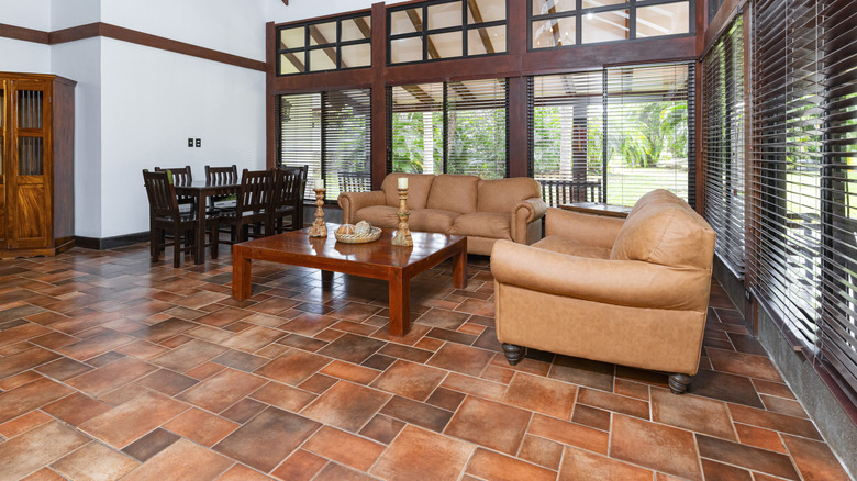 A spacious living and dining area with terracotta tile floor