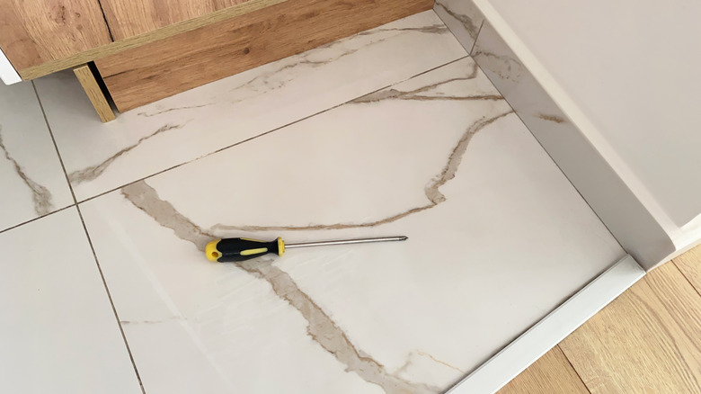 A close-up of a tiled floor with matching tile baseboards