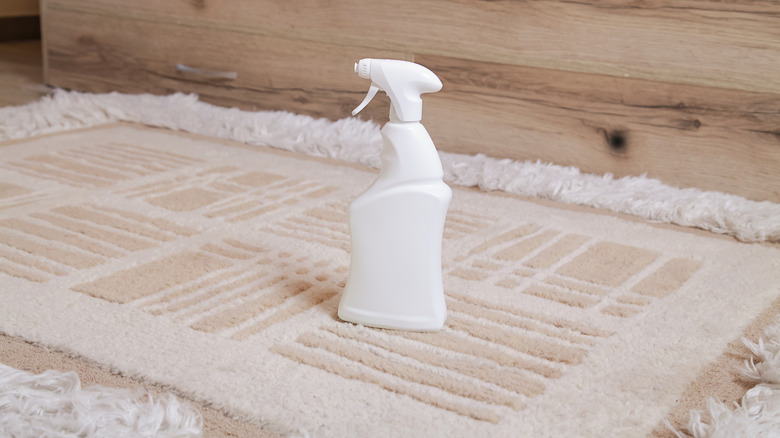 White spray bottle sitting on tan rug