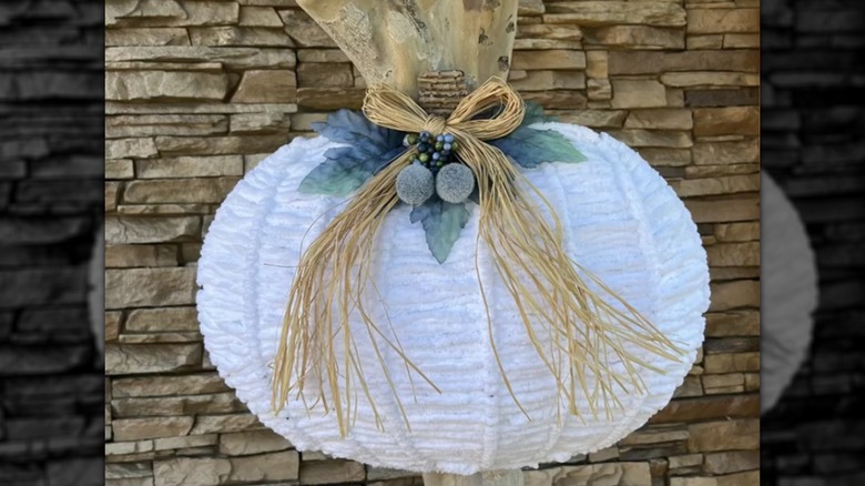 A pumpkin-shaped wreath form covered with weaved yarn
