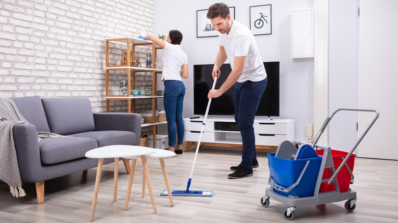 Man mopping floor with two-bucket system