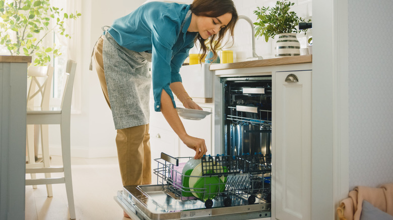 Woman loads dishwasher