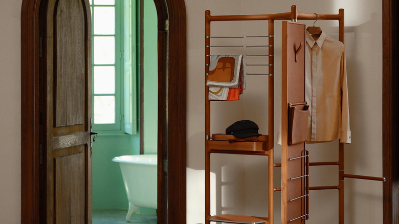 A luxury wooden clothing rack in a hallway.