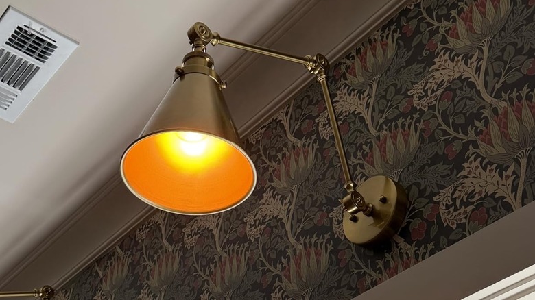 Amazon Jonathan Y industrial sconce installed on wall with moody wallpaper
