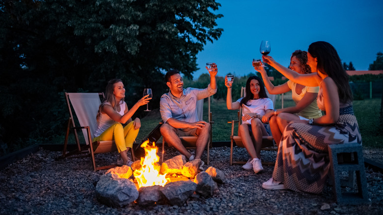 A group of friends gathered around a backyard fire