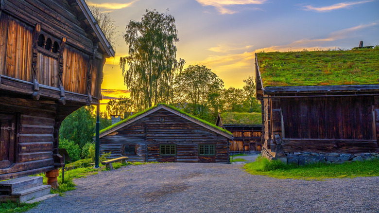 Traditional Norwegian homes and structures made of wood with a sunset sky.