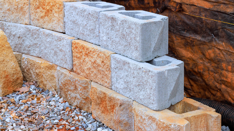 Interlocking concrete blocks in orange and gray used for a retaining wall