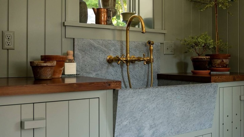 Kitchen with gray-green cabinets and rich wood countertops