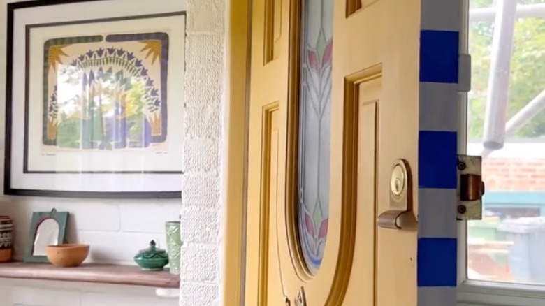 A yellow door with a blue and white striped edge