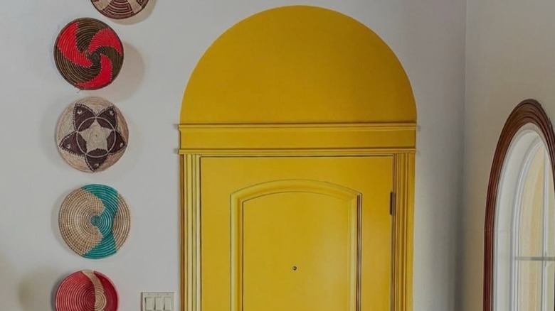 A bright yellow door topped with a matching yellow arch