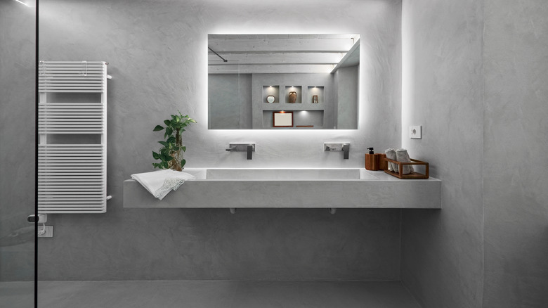 A modern bathroom with gray resin floors and walls