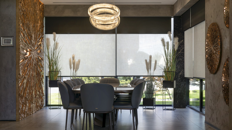 Modern dining room with motorized shades covering large windows.