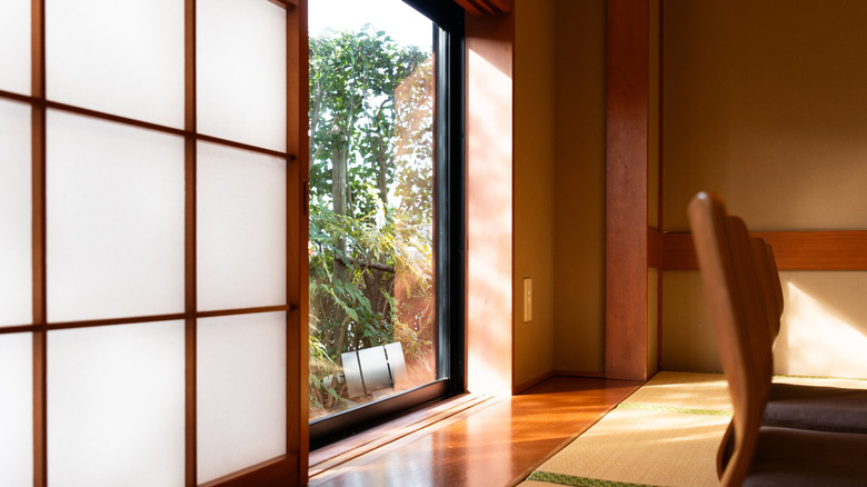 interior space featuring traditional Japanese design with shoji screens, wood accents and view of greenery outside