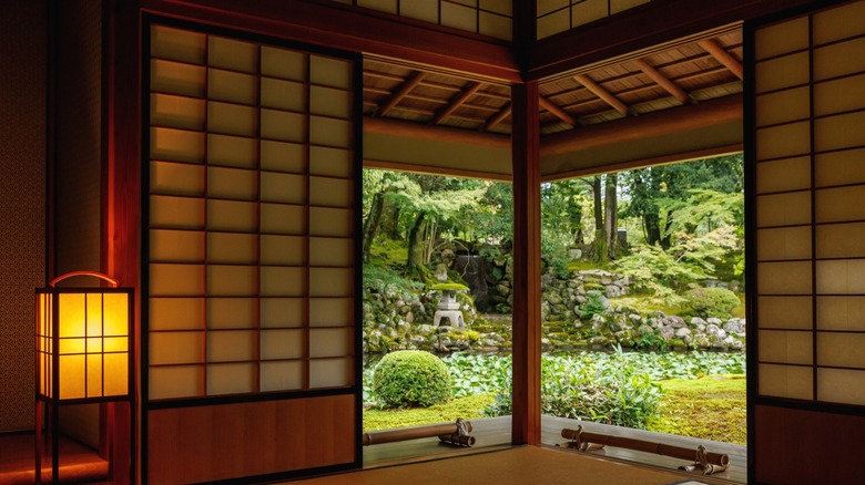 traditional Japanese room with shoji screens and mats with garden view