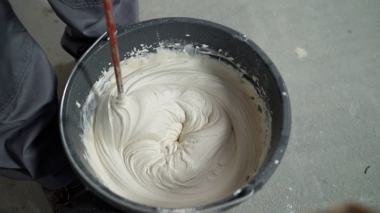 white plaster being mixed in a bucket