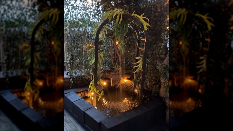 An archway in a small pond with a waterfall