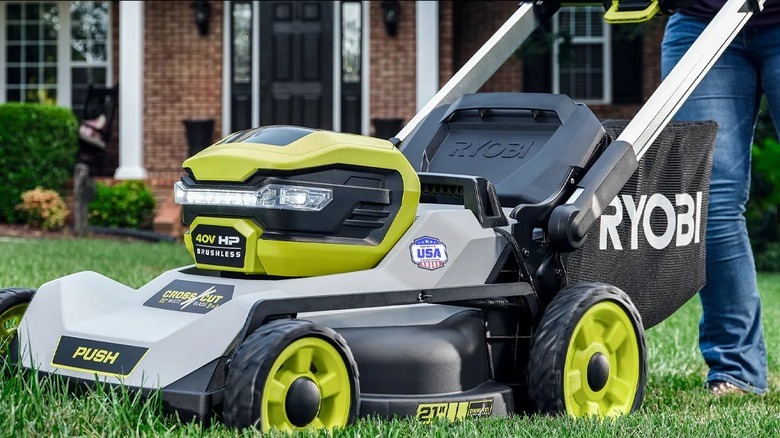 Person using a Ryobi lawn mower