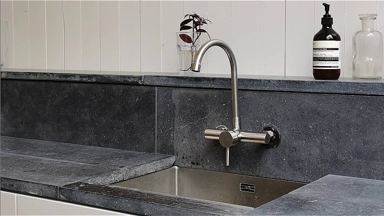 A sink with a bluestone countertop