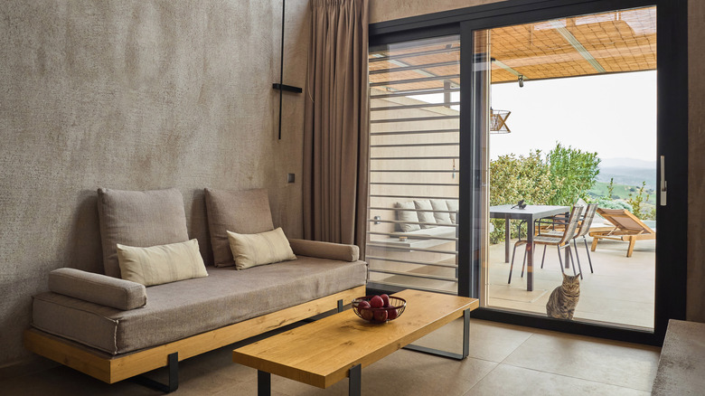 A rustic living room with sliding glass doors looking out onto a terrace