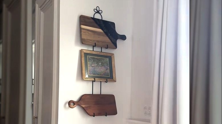 Tiered plate rack holding for cutting boards and a framed picture.