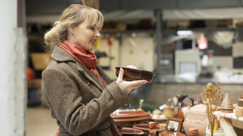 A blonde woman holding a ceramic dish.