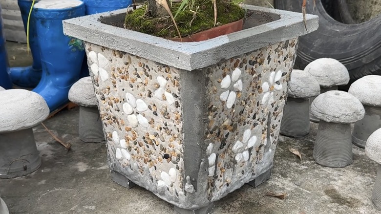 a DIY cement planter decorated with pebbles.