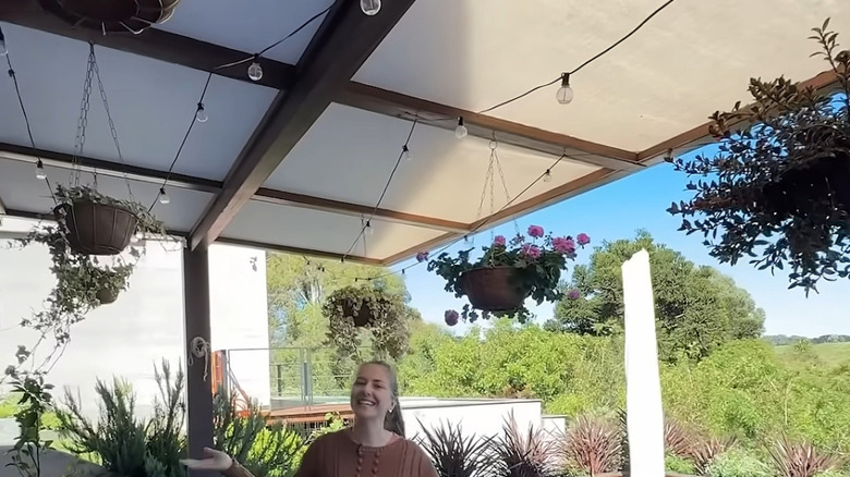shade cloth on a pergola with woman smiling beneath