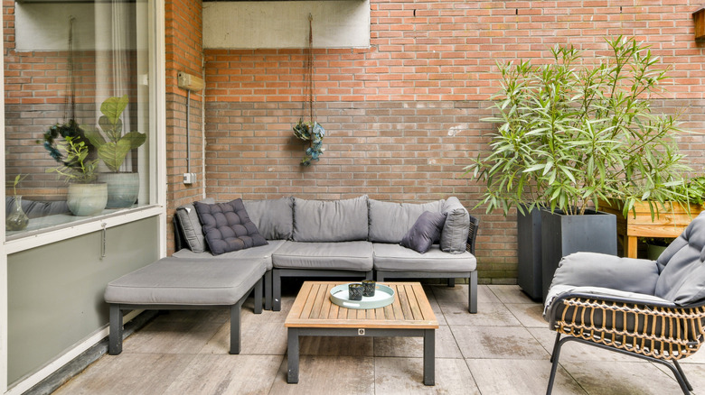 Patio with grey couch and wooden table
