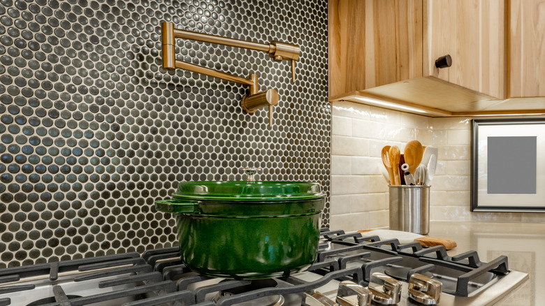 A gray penny tile backsplash over a modern stove.