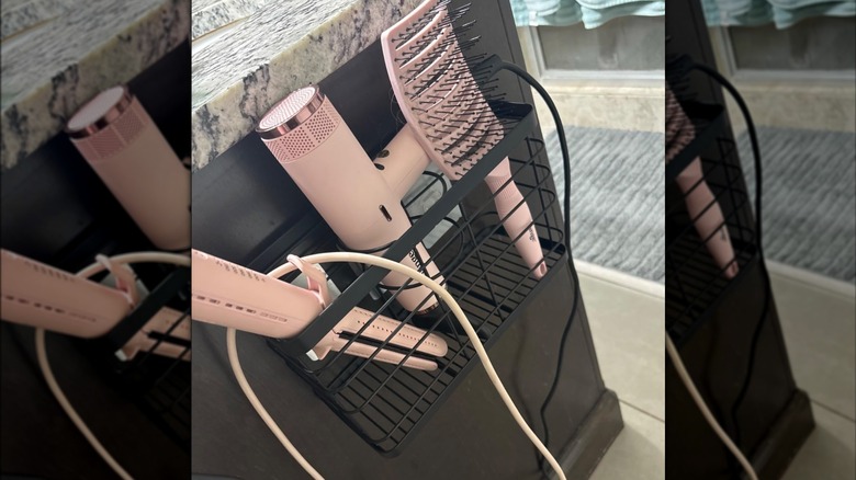 Organizer filled with pink hair tools on the side of a counter