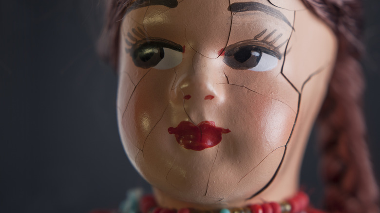 Close up of cracked porcelain doll face.