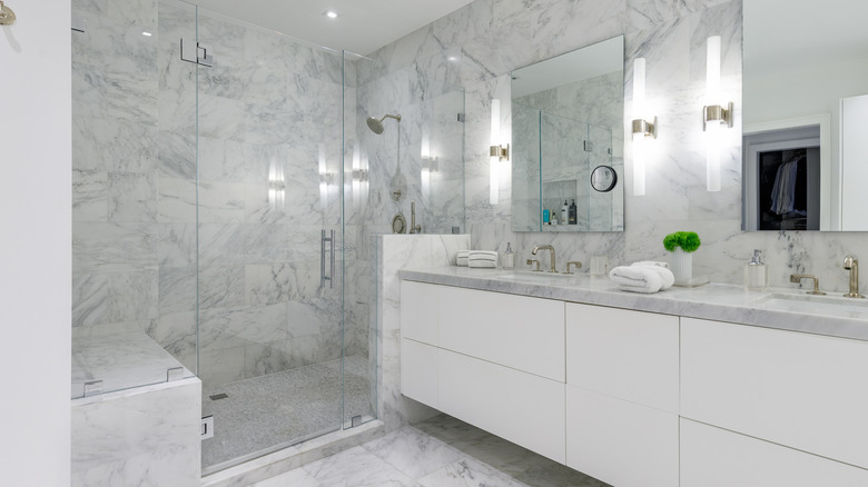 A bathroom with a white sink and frameless shower doors