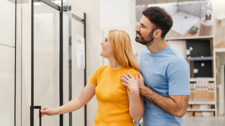 Couple looking at shower glass doors at a store