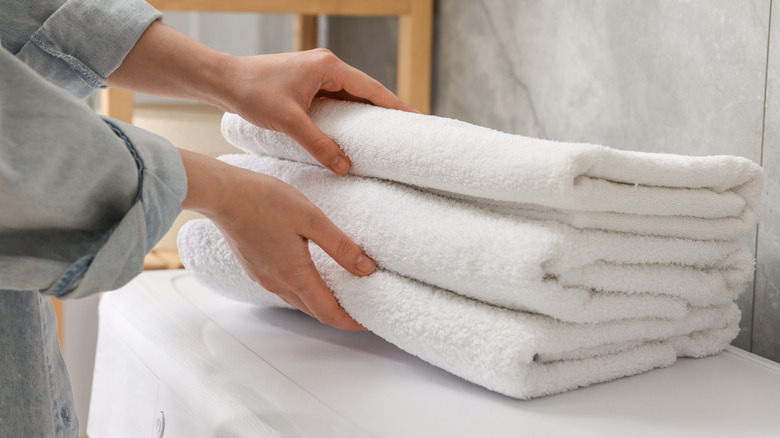 A stack of white towels taking up counter space