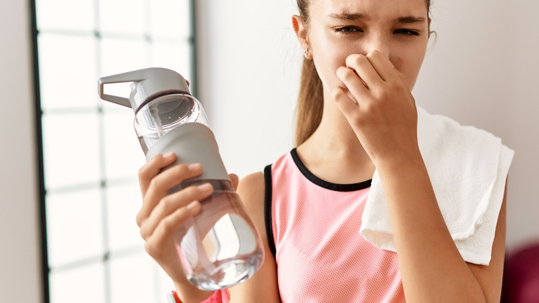 smelly water bottle in hand 