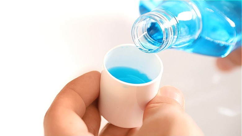 Pouring mouthwash over sink