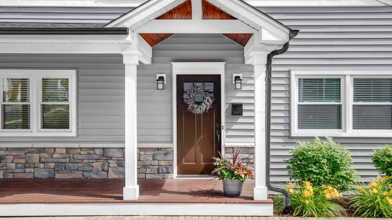 Pretty mixed container garden beside the front door of a house