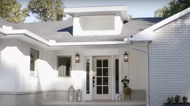 A white house with a light pink front door.