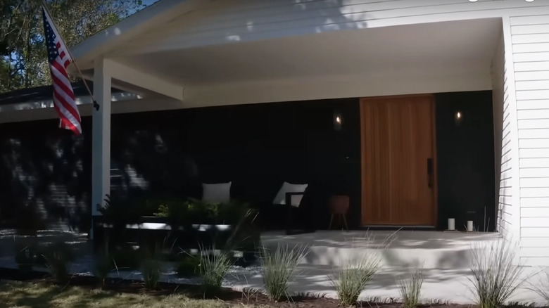 Modern front porch with a large wood door.